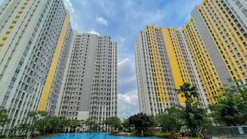 Un edificio residencial alto con una piscina al frente.