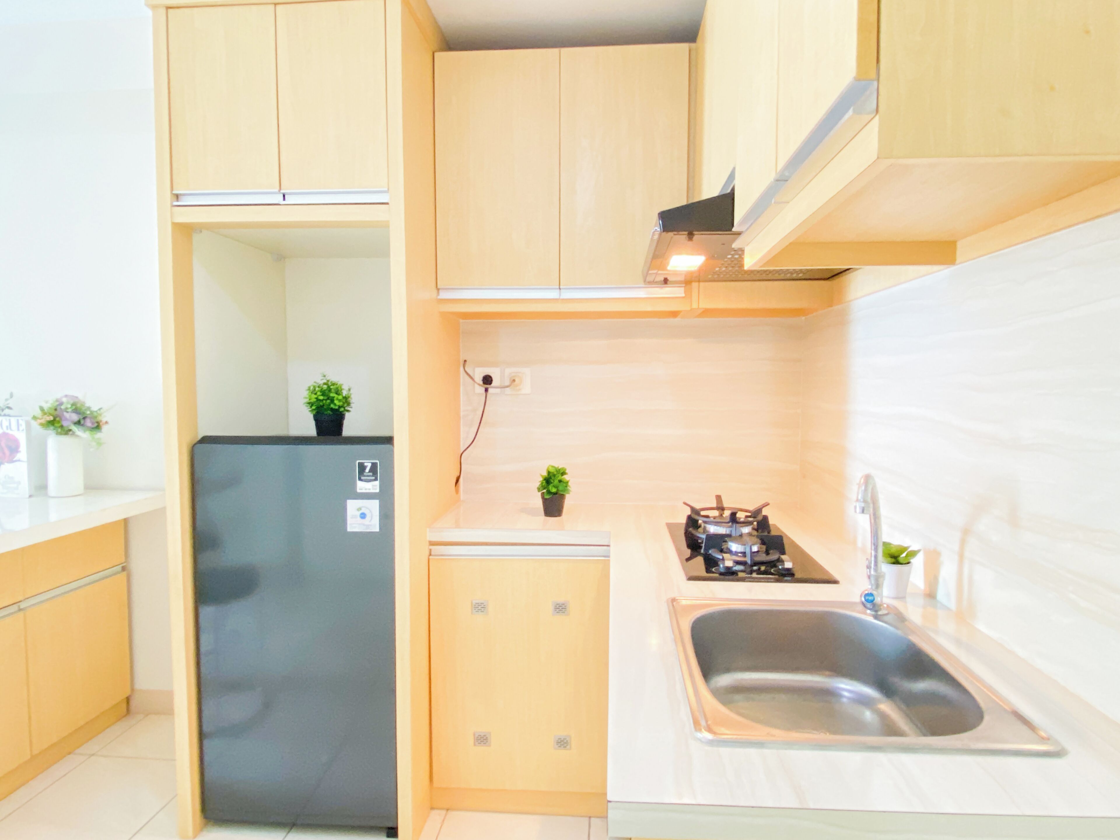Una cocina compacta con refrigerador integrado, lavamanos y estufa.