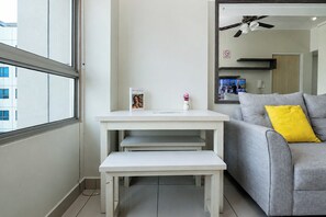 A modern living room with a grey sofa, a white table, and a window. - Compact With Minimalist Design 2Br At Springlake Summarecon Bekasi Apartment (Bekasi)