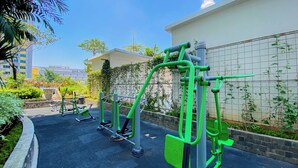 Trainingsgeräte im Freien in einem Innenhof, im Hintergrund ein Gebäude.