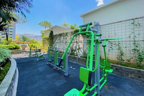 Outdoor exercise equipment in a courtyard with a building in the background. - Compact With Minimalist Design 2Br At Springlake Summarecon Bekasi Apartment (Bekasi)