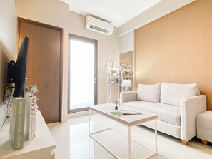 Ein modernes Wohnzimmer mit einem weißen Sofa, einem Couchtisch und einem Bücherregal.