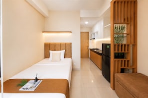 Ein Hotelzimmer mit Bett, Nachttisch und einer Küchenzeile.