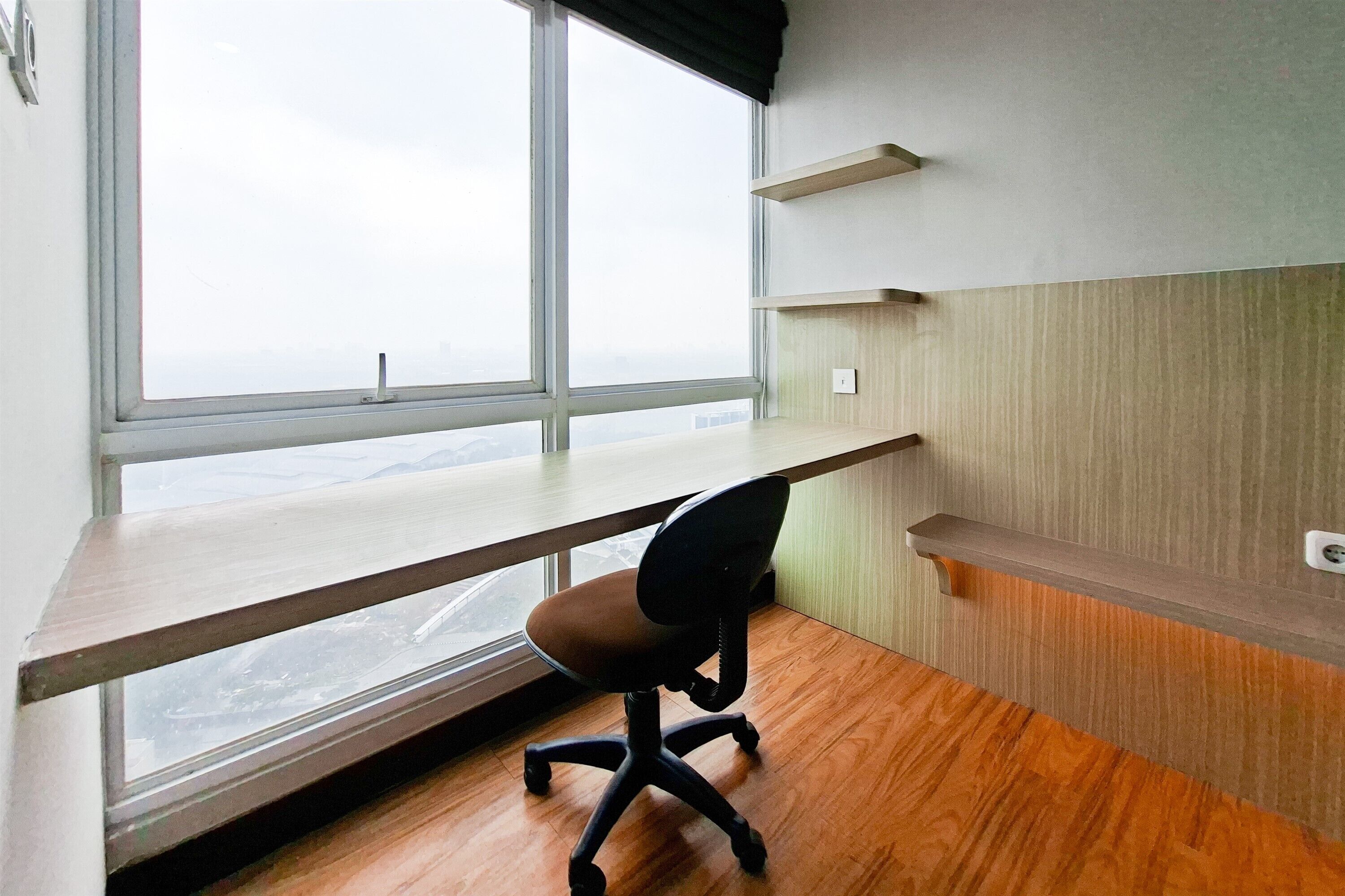 A room with a desk, chair, window, and shelves.