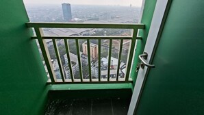 A view from a balcony with a metal railing, overlooking a cityscape with buildings and a bridge. - Cozy And Warm Full Furnished Studio Room At Apartment B Residence (Tangerang)