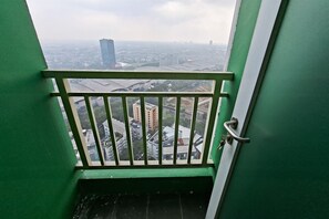 Blick von einem Balkon mit Metallgeländer auf einen Stadtblick mit Gebäuden und einer Brücke.