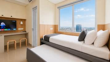 Quarto de hotel moderno com cama, televisão, escrivaninha e janela com vista para a cidade.