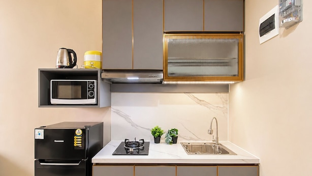Una cucina compatta con forno a microonde, fornello e lavandino.
