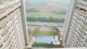 Un edificio de gran altura con piscina y vista a una autopista.