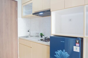 Una cocina con un refrigerador azul, un fregadero y una estufa.