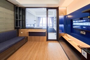 Ein modernes Interieur mit einer Sitzecke, einem Schreibtisch und einem Fernseher, der eine Speisekarte zeigt.