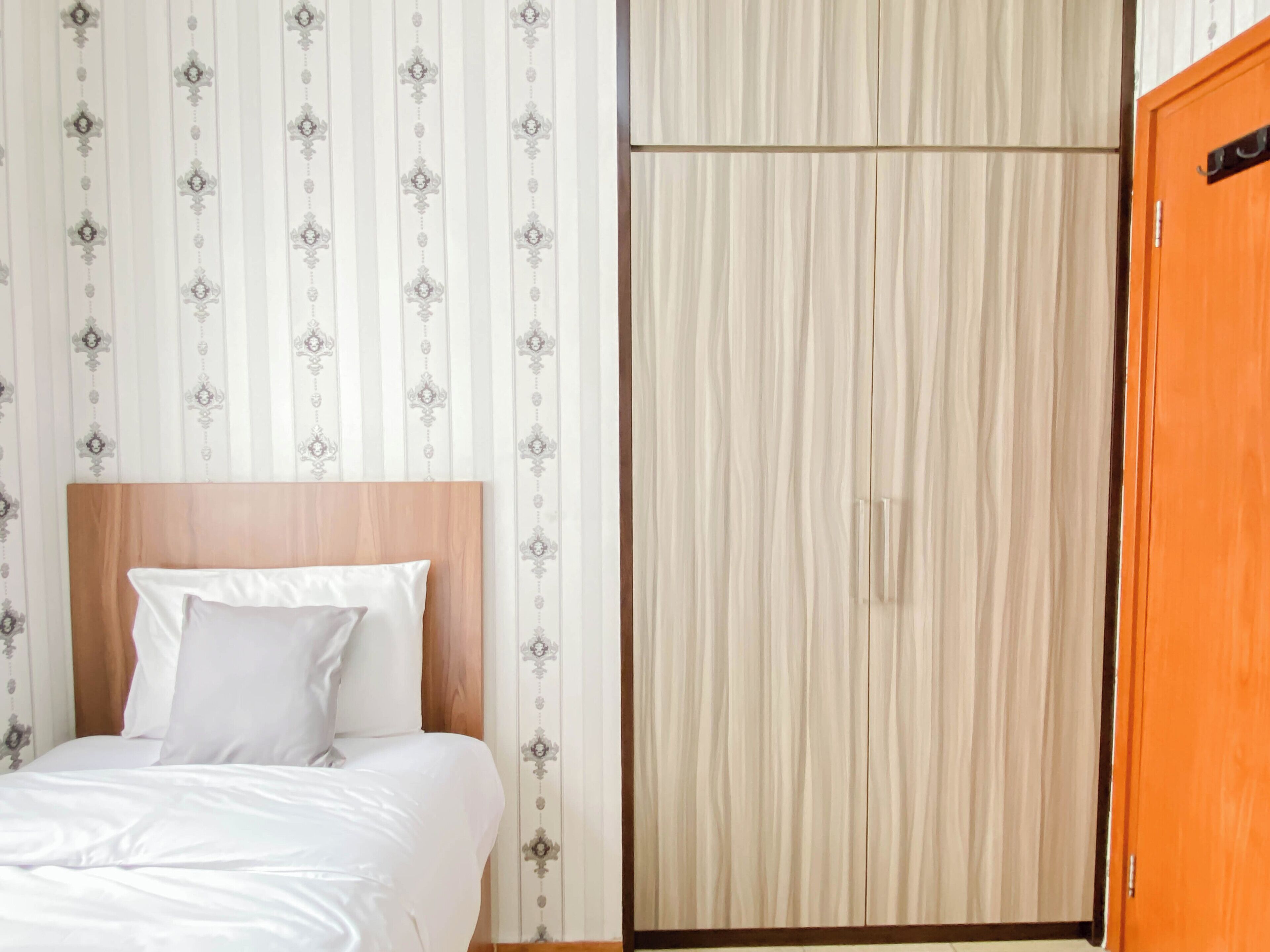 Une chambre d’hôtel avec un lit, une armoire et une porte.