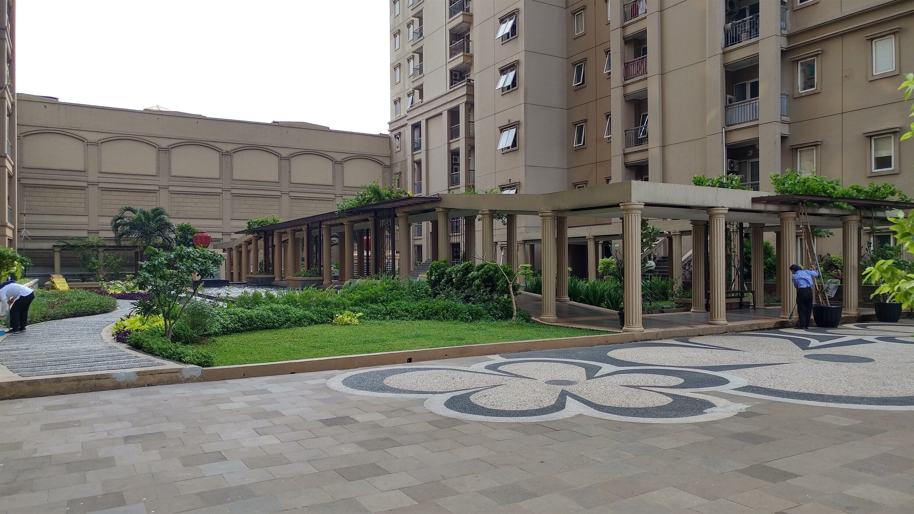 Un cortile con una galleria coperta, una zona decorata con piastrelle e un edificio con numerosi balconi.