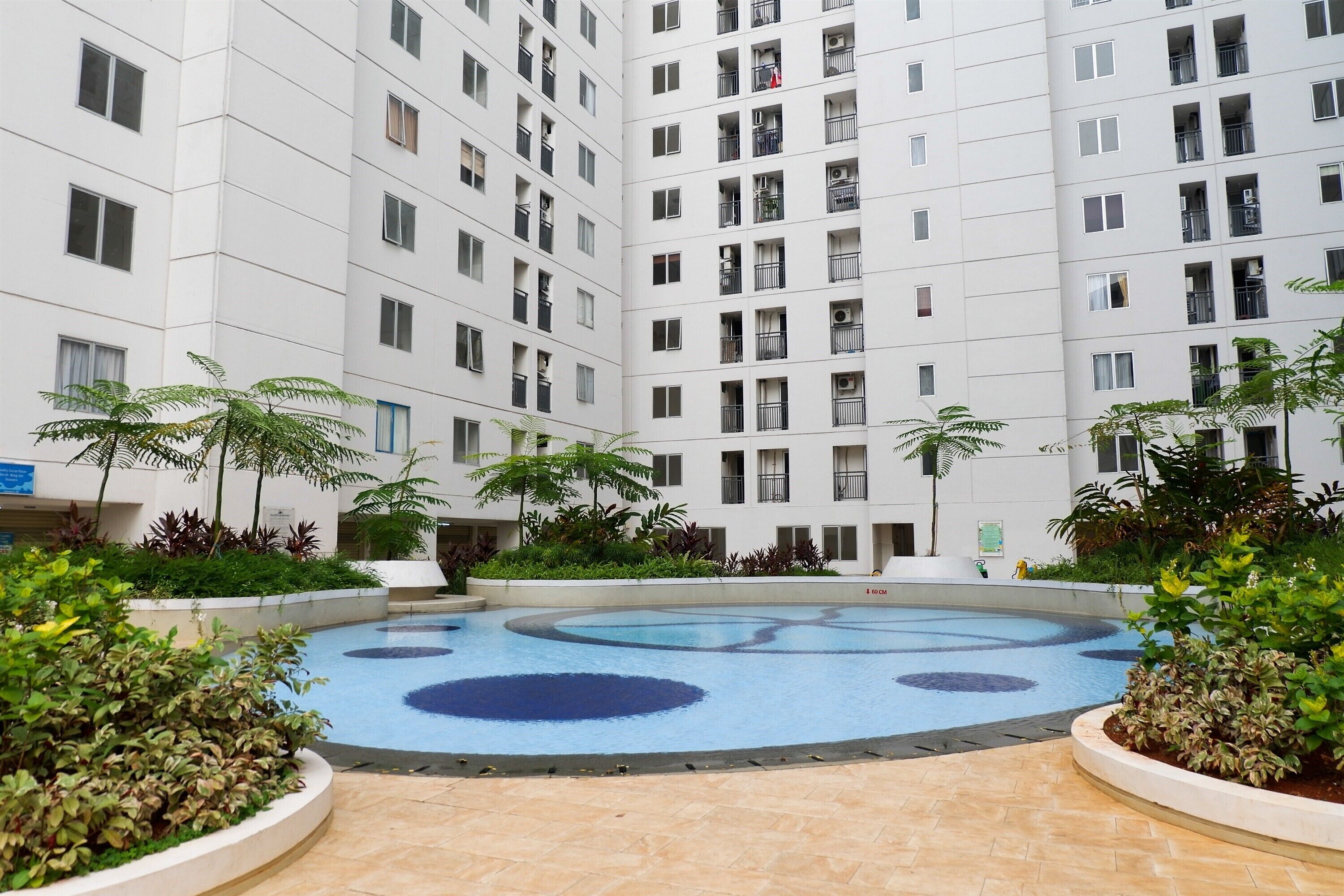 A courtyard with a swimming pool, surrounded by multi-story residential buildings.