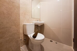 A bathroom with a toilet, a sink, and a mirror. - Comfortable And Functional Studio Room At Apartment Transpark Bintaro (South Tangerang)