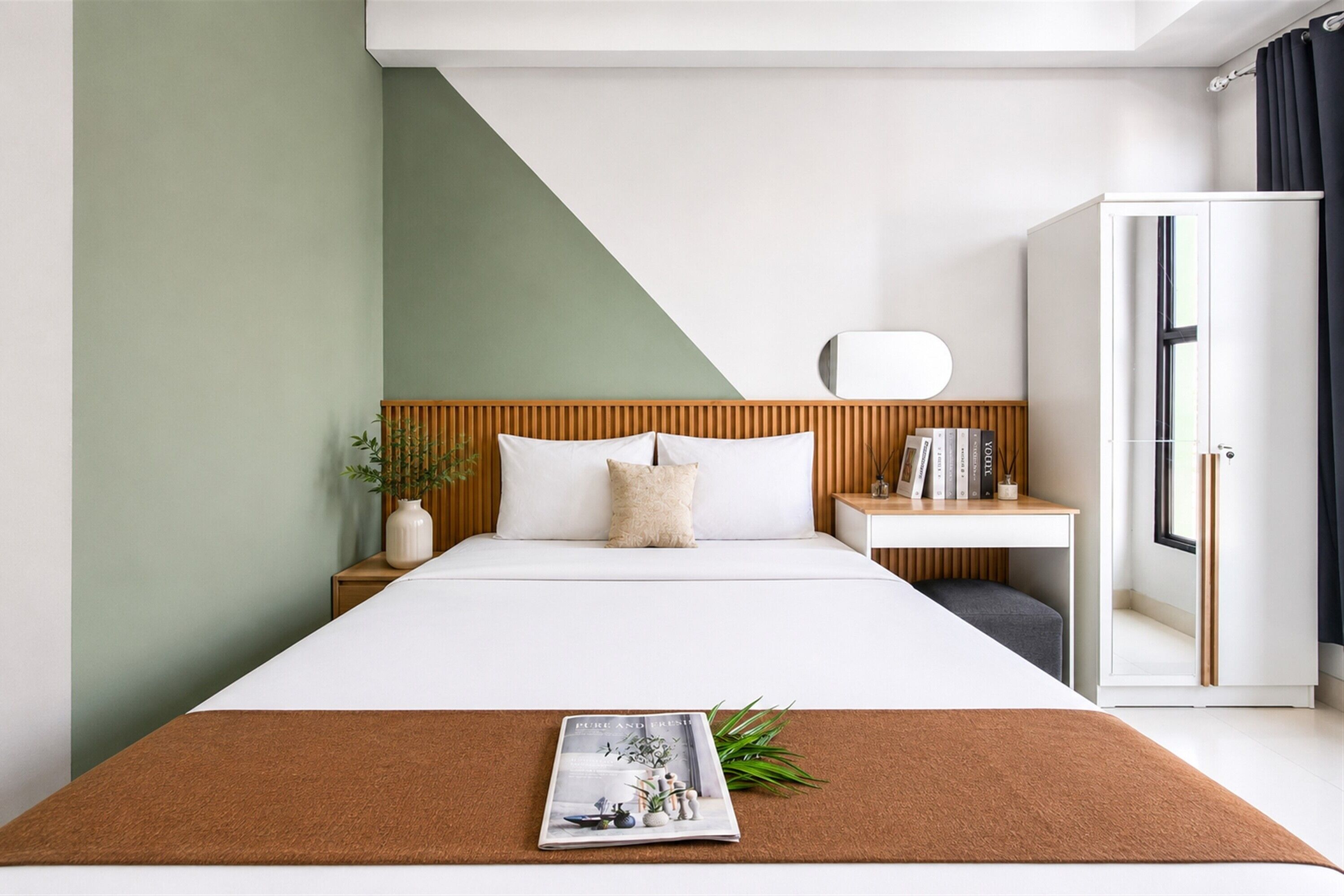 Een moderne hotelkamer met een bed, nachtkastje en kledingkast.