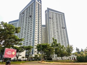 A high-rise building with multiple balconies and a sign indicating a show unit.