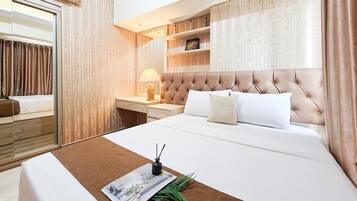 A hotel room with a large bed, a bedside table with a lamp, a mirror, and a wardrobe.