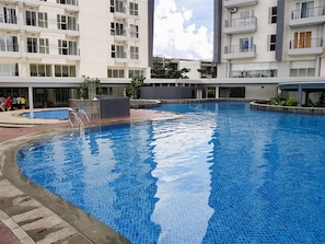 A modern residential building with a swimming pool. - Airy Studio At Casa De Parco Apartment (Tangerang)