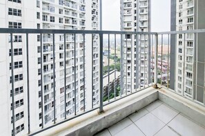 A high-rise residential building with multiple balconies, a tiled floor, and a clear view of the surrounding area.