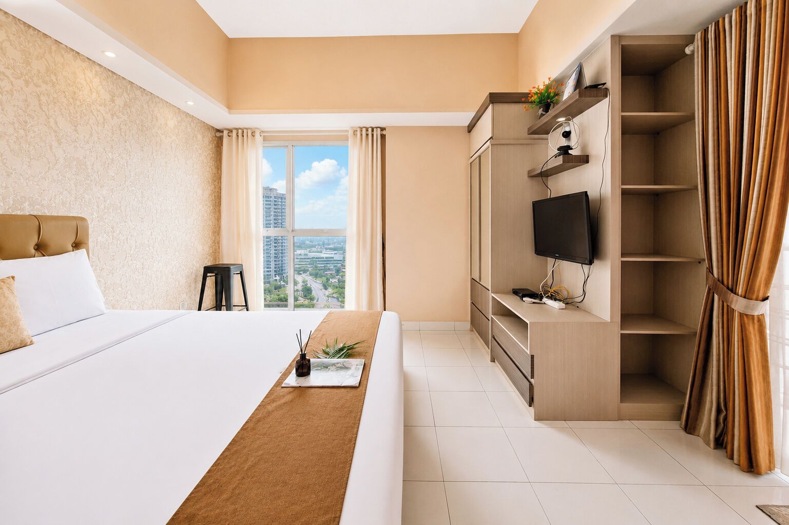 Habitación de hotel con cama, televisión, escritorio y vistas a la ciudad.