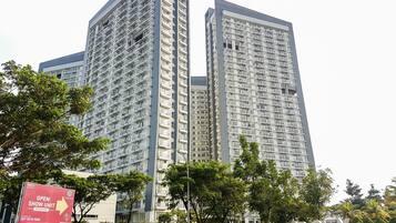 A high-rise building with multiple balconies and a sign indicating a show unit.