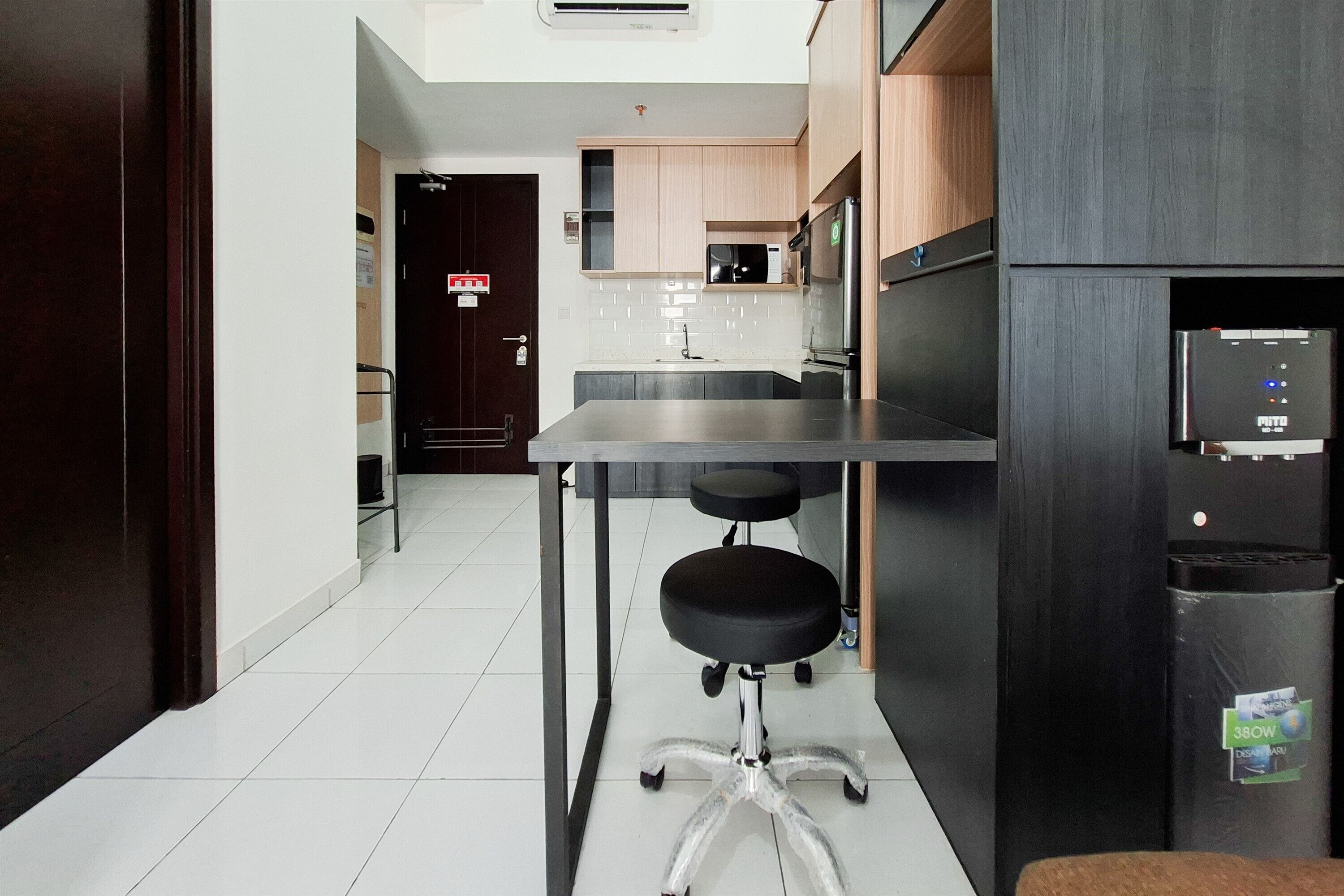 Una cocina moderna con encimera de acero inoxidable, microondas y refrigerador.