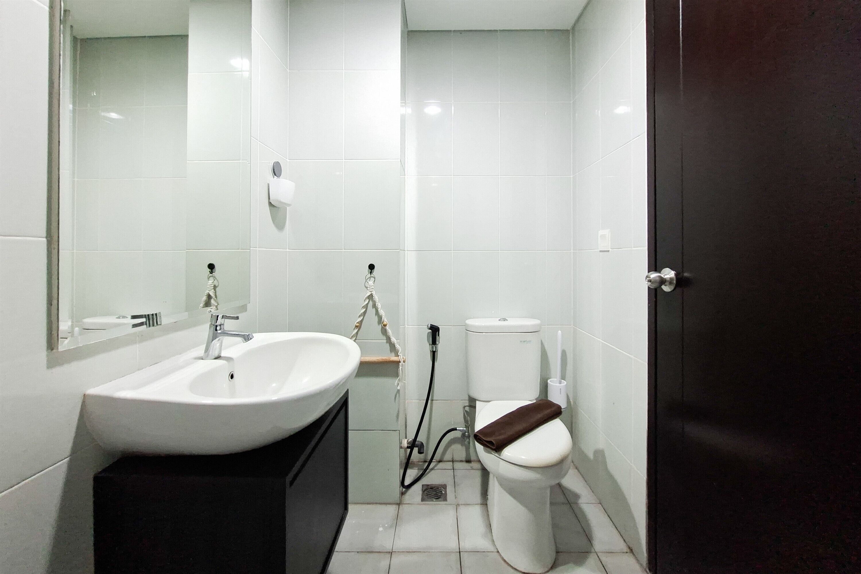 A bathroom with a white sink, mirror, and toilet.