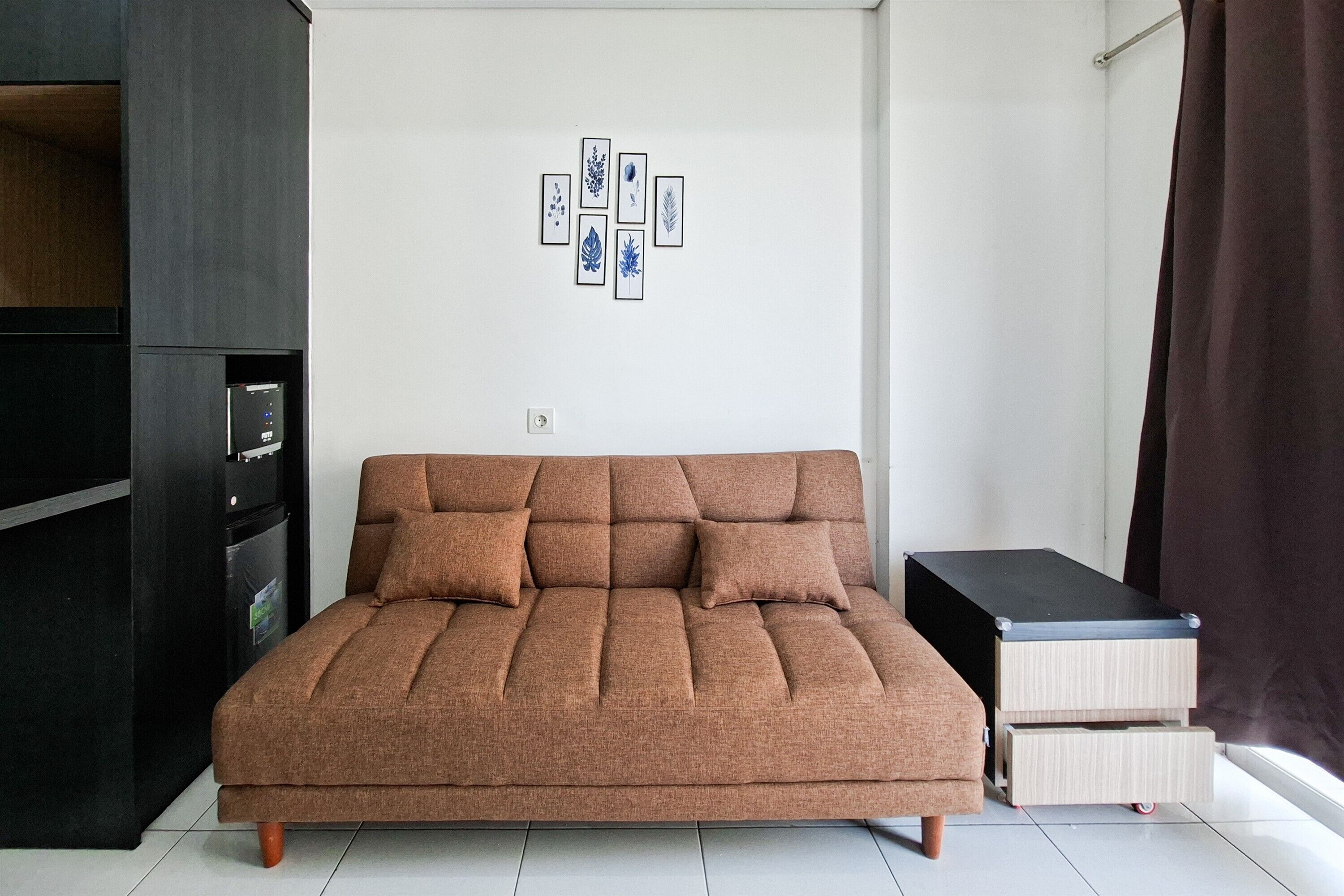 A modern living room with a sofa, a small cabinet, and a wall-mounted artwork.