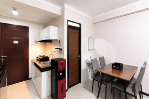 Una cocina compacta con estufa, fregadero y una mesa con sillas.