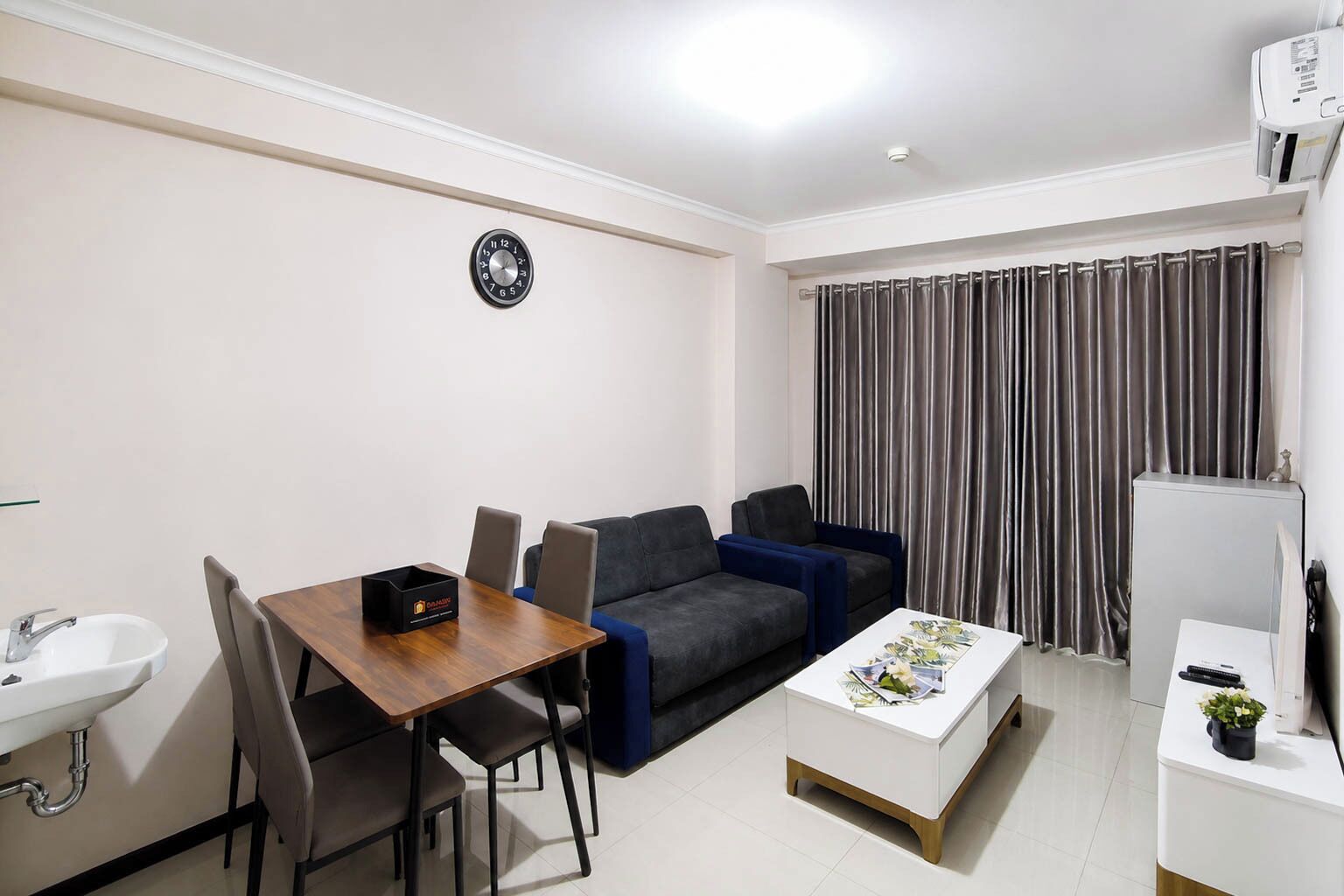 Un espacio habitable compacto con una mesa de comedor, sofá y una pequeña kitchenette.