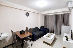 Un espacio habitable compacto con una mesa de comedor, sofá y una pequeña kitchenette.
