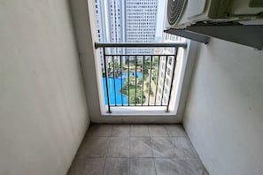 A small balcony with a view of a residential area and a swimming pool. - Modern 3Br Apartment With Chic Style At M-Town Residence (Tangerang)
