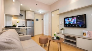 Uma sala de estar moderna com um sofá, uma mesa de centro e uma televisão de tela plana fixada na parede.