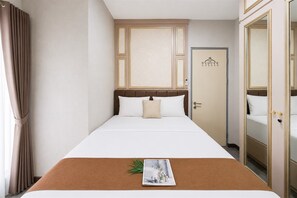 Ein Hotelzimmer mit Bett, Tür und Spiegel.