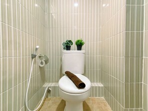 Ein Badezimmer mit Toilette, Dusche und einem Handtuch auf dem Sitz.