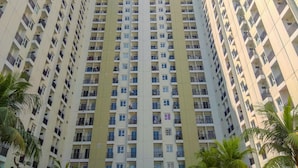 Um edifício residencial alto, com várias varandas e janelas.