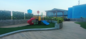 A playground with slides and a covered seating area. - Simply And Cozy Studio Apartment At Suncity Residence (Sidoarjo)