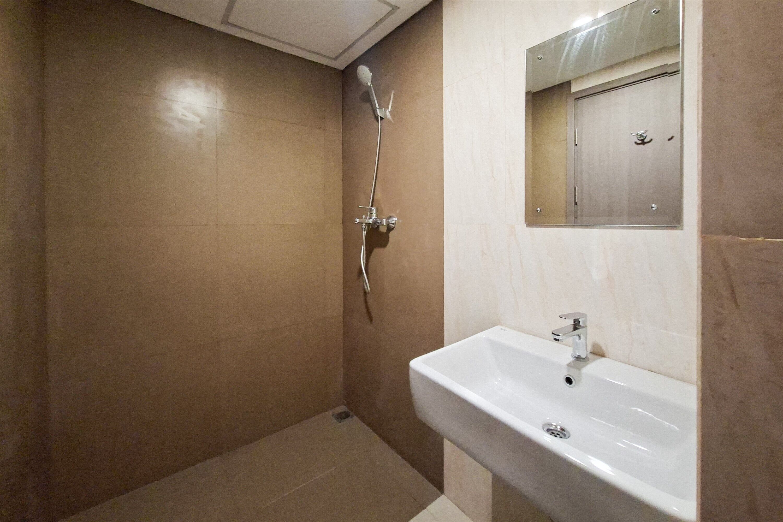 Un baño con ducha, lavamanos y espejo.