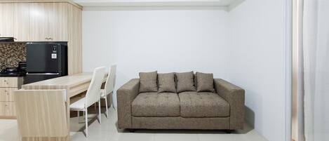 A compact living space with a kitchenette, a sofa, and a dining table.