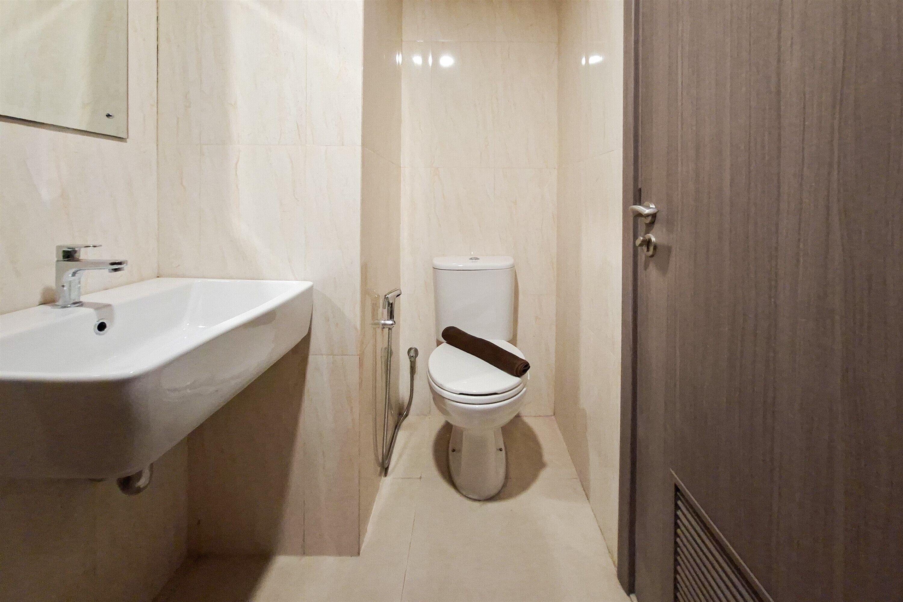 Een badkamer met een wit wastafelmeubel, een toilet en een douche.