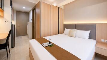 Quarto de hotel moderno com uma cama grande, uma escrivaninha e um guarda-roupa.