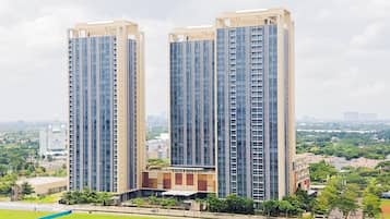 Two high-rise buildings with a sports field in the foreground.