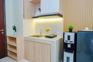 Una cocina compacta con pileta integrada, estufa y refrigerador.