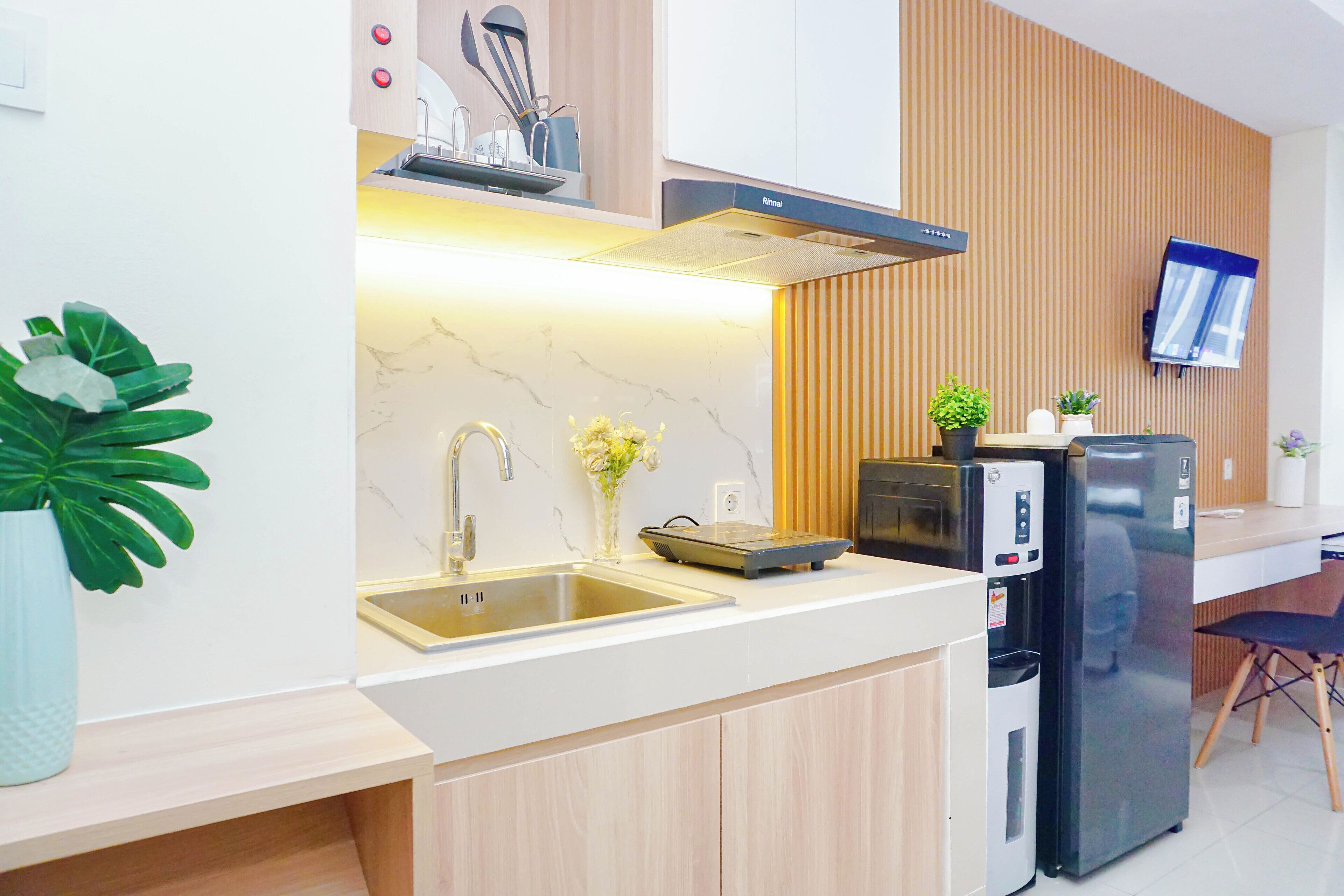 A modern kitchen with a built-in stove, a sink, and a refrigerator.