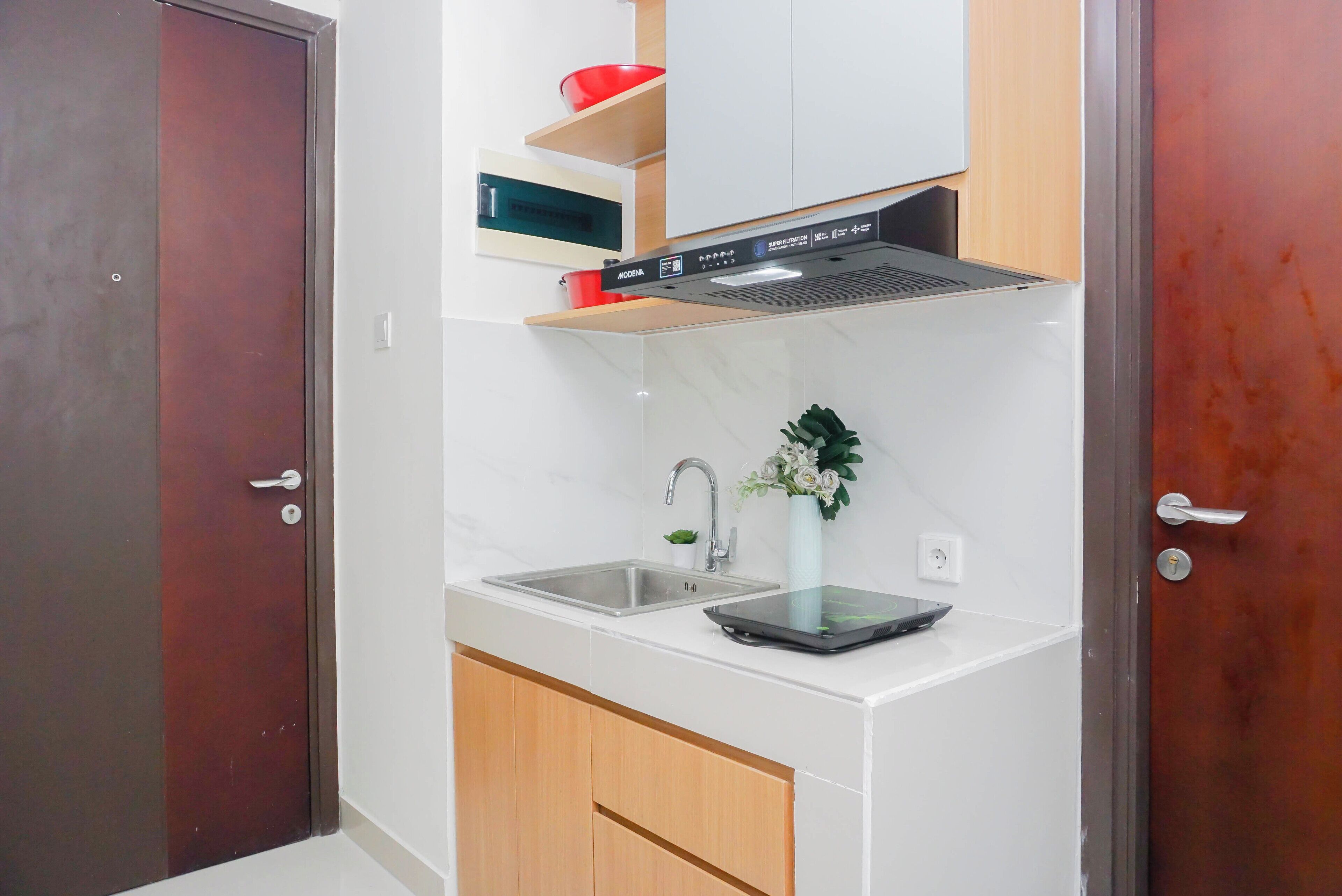 A compact kitchen with a built-in microwave, a stainless steel sink, and a compact stove.