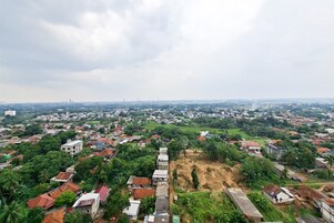 Um bairro residencial com casas, áreas verdes e um horizonte urbano ao longe.