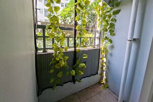 Una habitación con ventana, una reja metálica y un tubo fijado a la pared.
