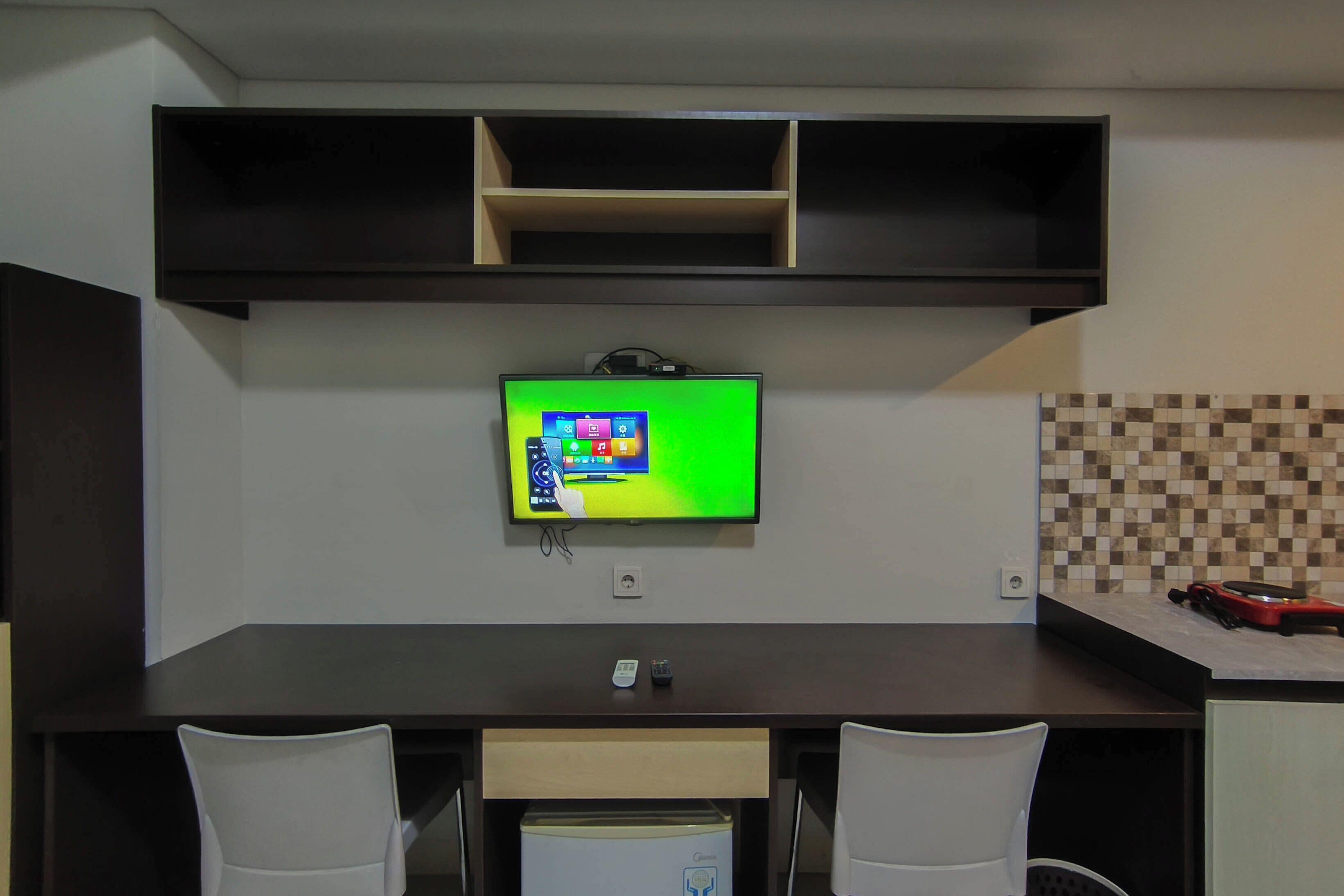 Una cocina moderna con una televisión integrada, una mesa de comedor con sillas y un salpicadero de azulejos.
