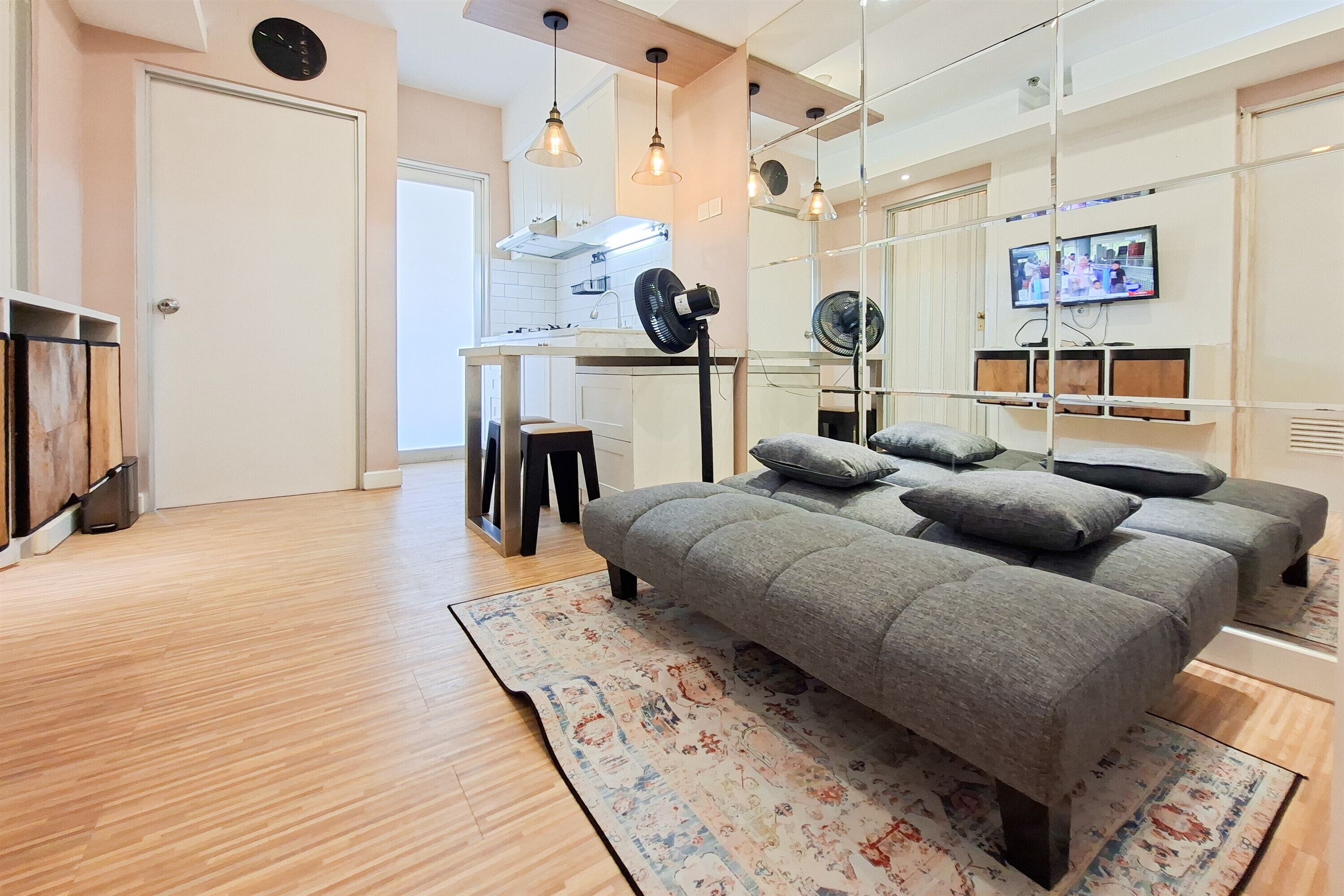 A modern bedroom with a large bed, a desk, and a television.